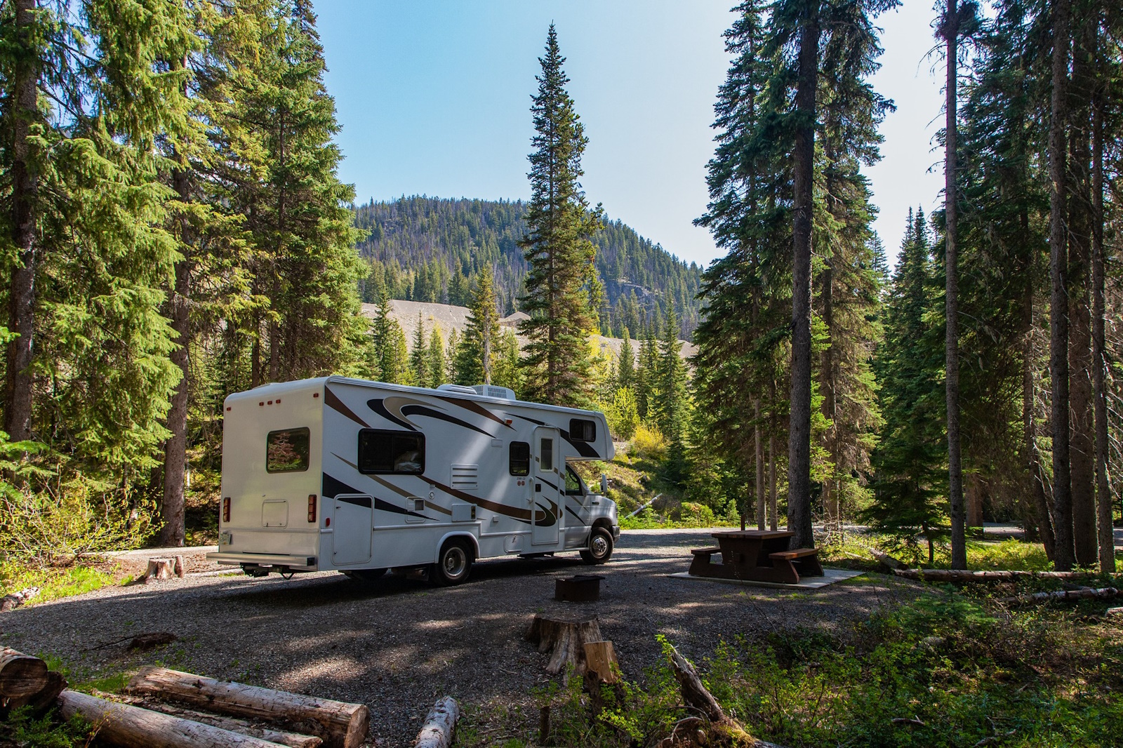 beautiful-campsite-mountains-with-rv-wooden-bench